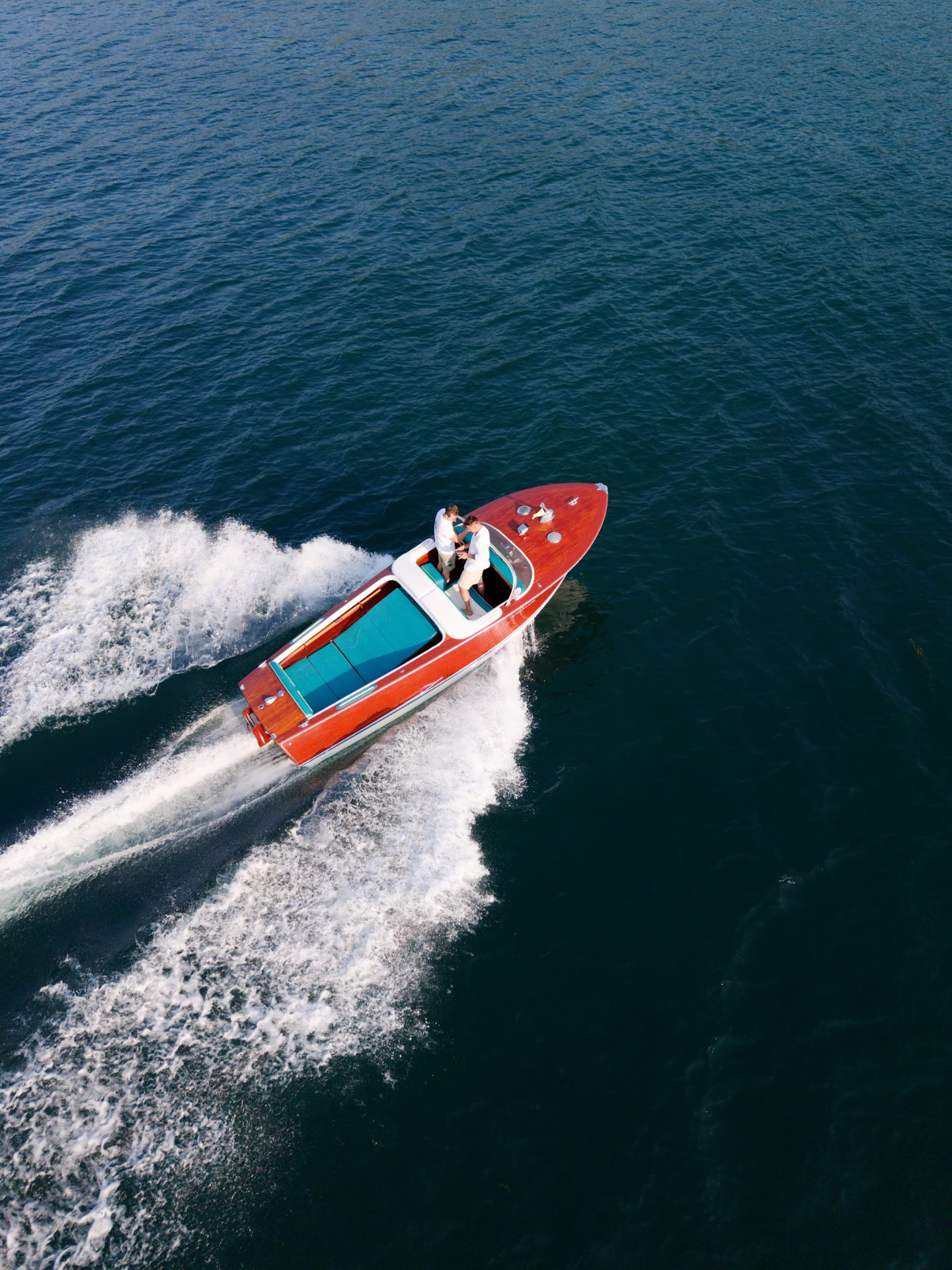 Aerial view of the wooden boat carving a wake across the lake