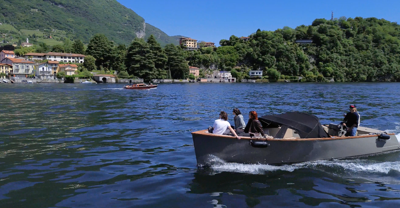 Cooper 800 cruising with passengers across Lake Como near a wooded shoreline