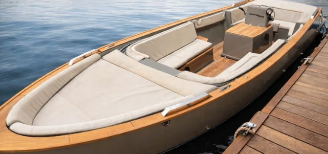 Cream upholstered cockpit and teak trim of the Cooper 800 alongside a wooden jetty